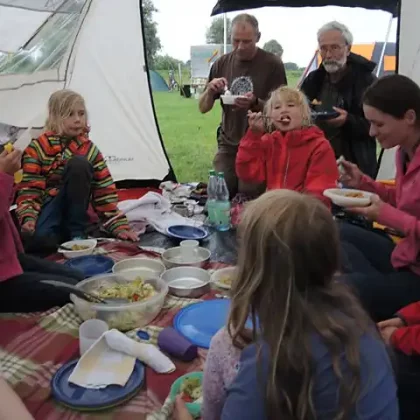 Kinder und Betreuer im Zelt beim Essen
