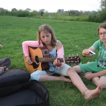 Kinder mit Gitarre auf dem Rasen