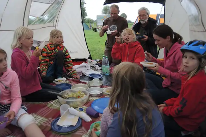 Kinder und Betreuer im Zelt beim Essen